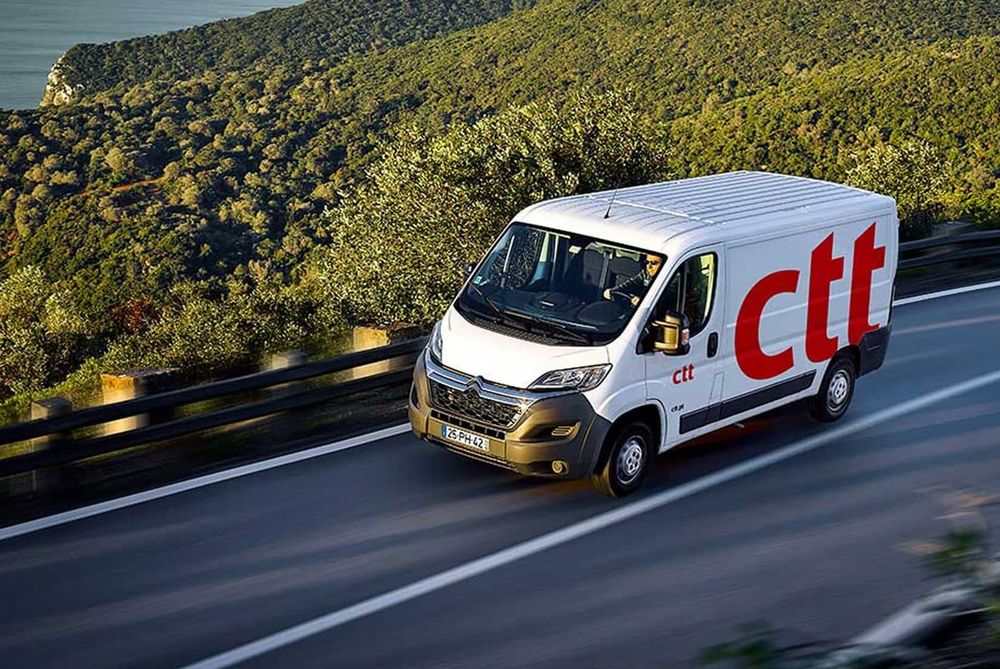 Carrinha dos CTT numa estrada costeira em Portugal