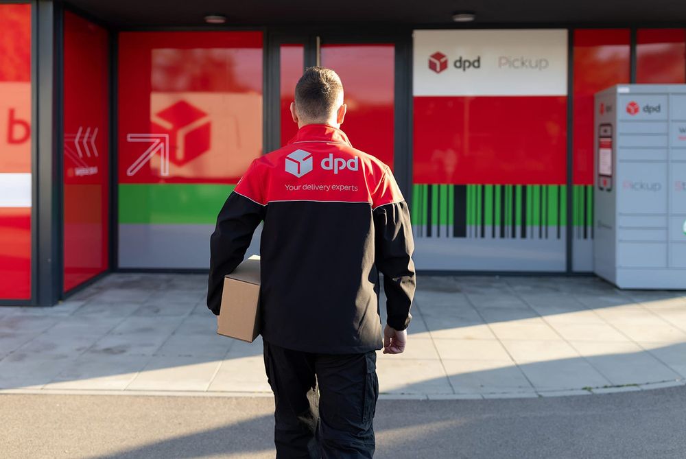 Estafeta da DPD a caminho de um ponto Pickup, com uma encomenda debaixo do braço